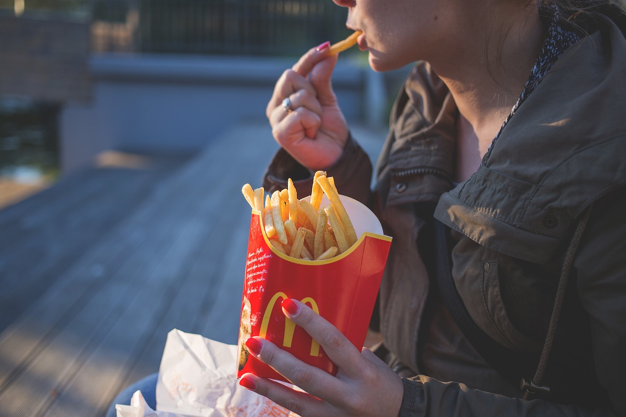 Γυναίκα τρώει τηγανιτές πατάτες από τα McDonald's